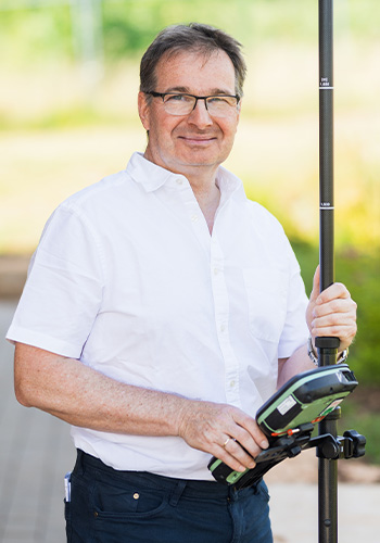 Porträt von Inhaber Jürgen Arhelger vom Vermessungsbüro – erfahrene Vermessungsdienstleistung im Einsatz für Grundstücksaufnahmen.