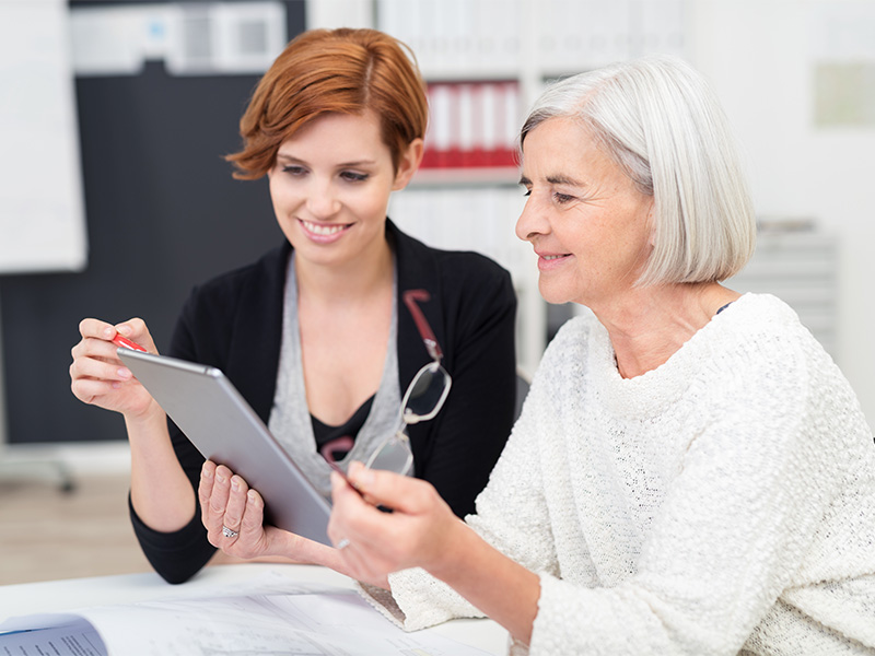 Inhaberin und Tochter prüfen gemeinsam auf einem Tablet die Nachfolgeplanung in Wetzlar für ein erfolgreiches Unternehmen.